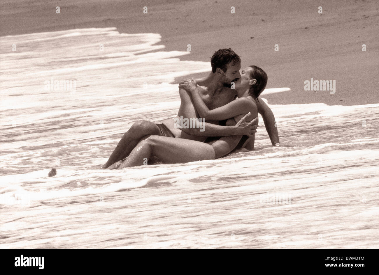 Giovane all'aperto all'aperto sabbia spiaggia vacanza vacanze vacanze mare costa kiss baciare in amore romano di acqua Foto Stock