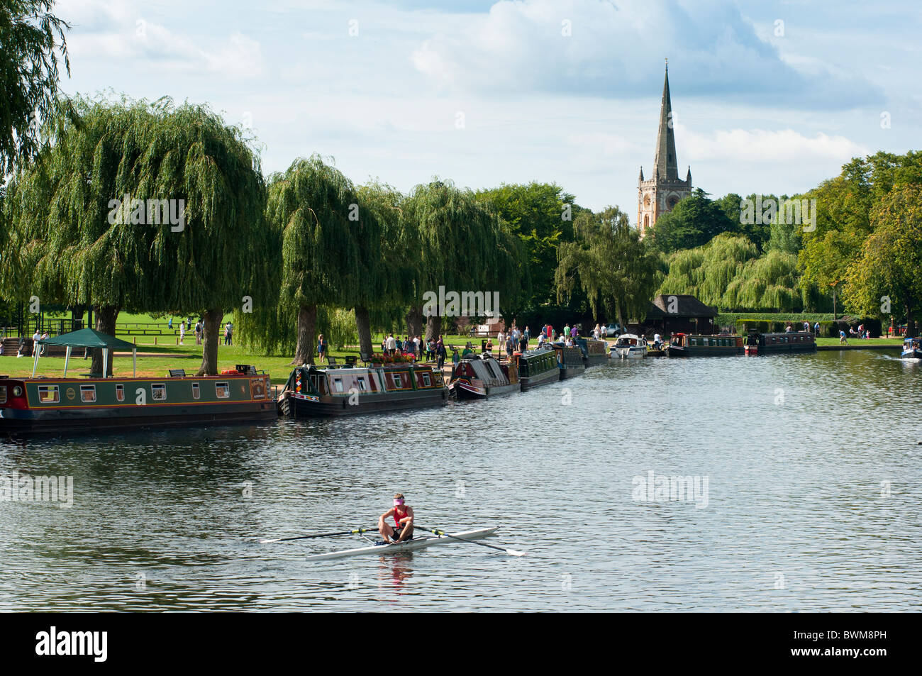 Una ripresa panoramica del fiume e lui chiesa della Santa Trinità come un vogatore va passato. Stratford upon Avon, Inghilterra. Foto Stock