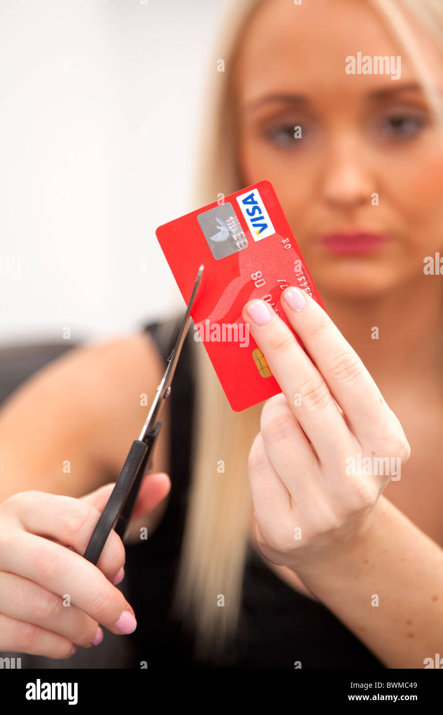 Giovane donna bionda taglio la sua carta di credito. Foto Stock