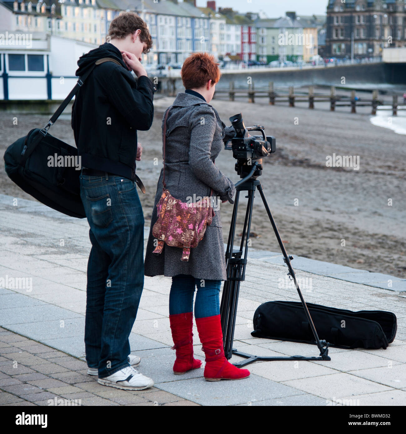 Un Media studies studente a aberystwyth university utilizzando una videocamera su un treppiede, Wales UK Foto Stock