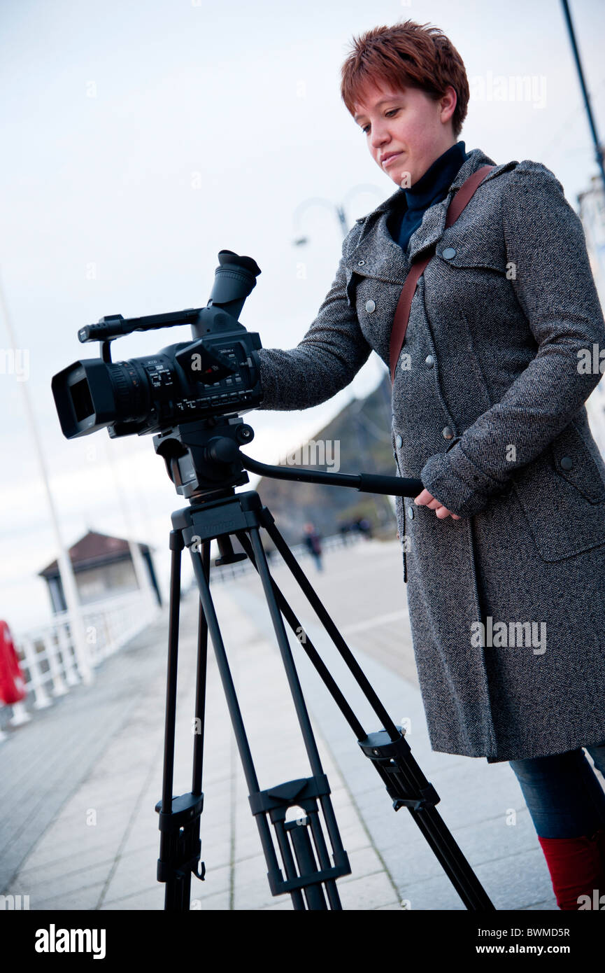 Un Media studies studente a aberystwyth university utilizzando una videocamera su un treppiede, Wales UK Foto Stock