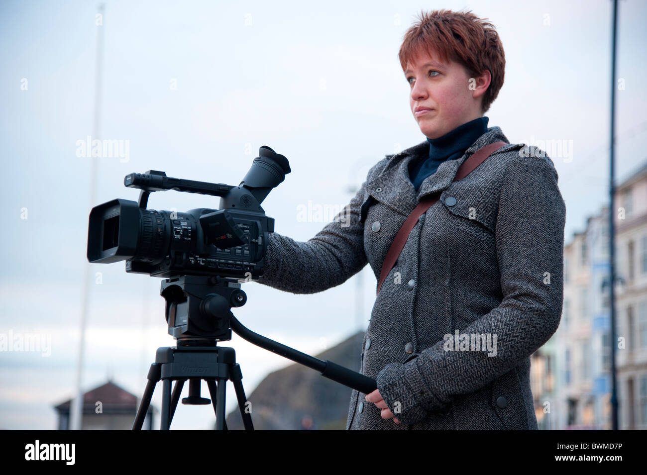 Un Media studies studente a aberystwyth university utilizzando una videocamera su un treppiede, Wales UK Foto Stock