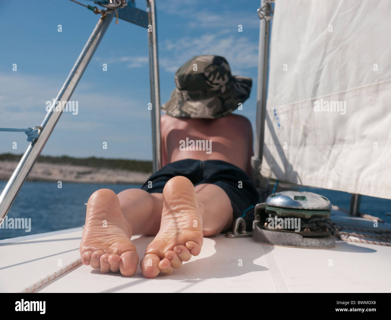 Dieci anni di vecchio ragazzo si rilassa sul ponte della barca charter Croazia hvar Foto Stock