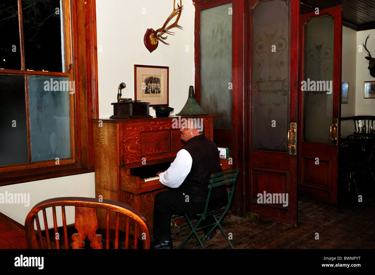 Un uomo suonare il pianoforte e canto presso un pub. Matjiesfontein, Sud Africa. Foto Stock
