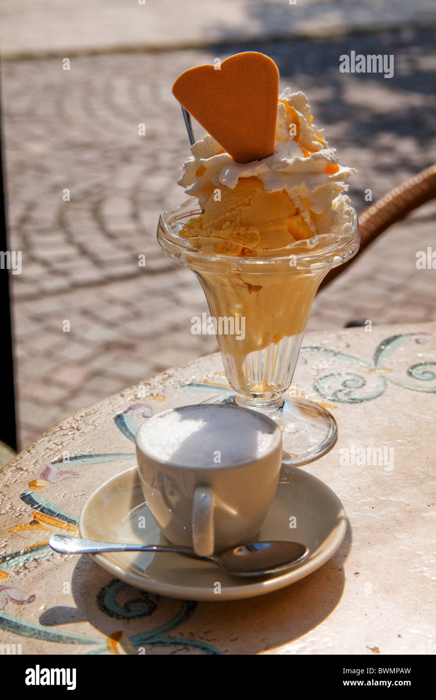 Il cappuccino e il gelato su un tavolo del bar sul lungolago - Lago di Garda - Garda Trentino Foto Stock