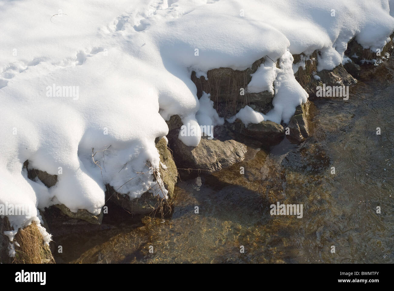 Paese di scena del Creek con neve e rocce Foto Stock