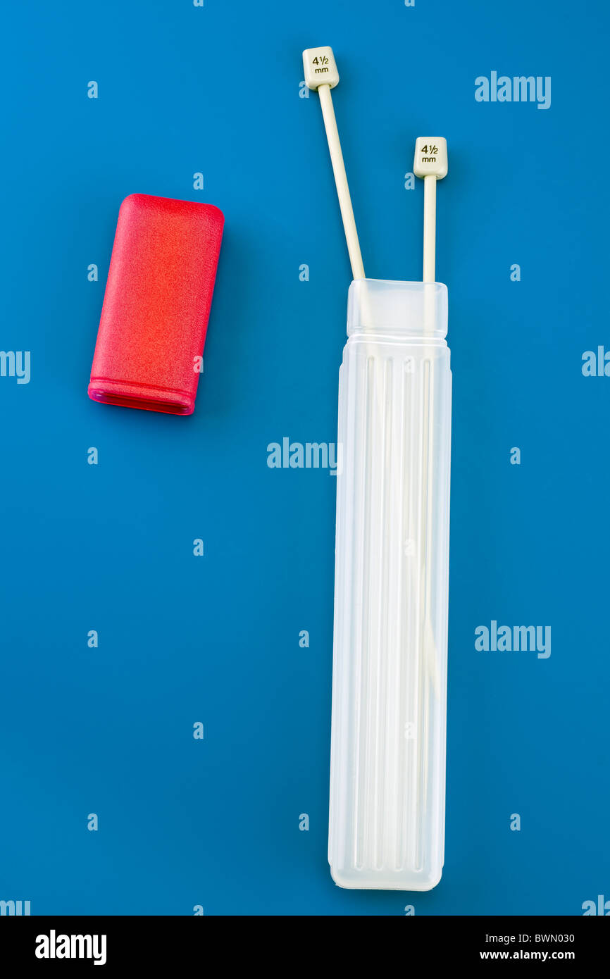 Lungo rosso in plastica e rabboccato ago da maglieria contenitore e due 4,5 mm aghi Foto Stock