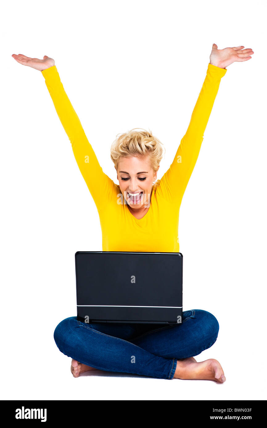 Attraente giovane donna utilizzando laptop - Celebra il successo Foto Stock