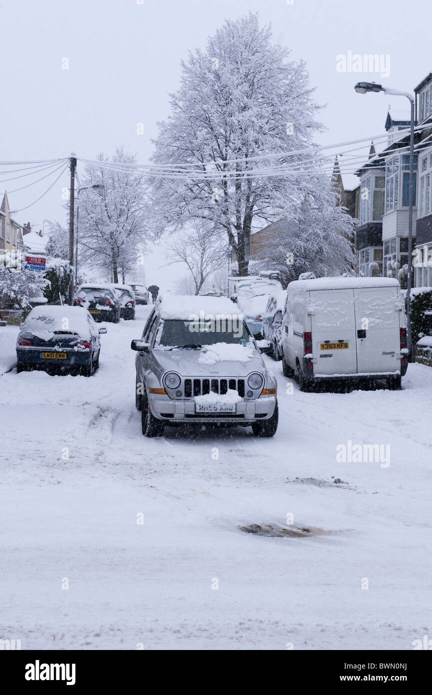 Una Jeep essendo condotta lungo una strada innevata. Foto Stock