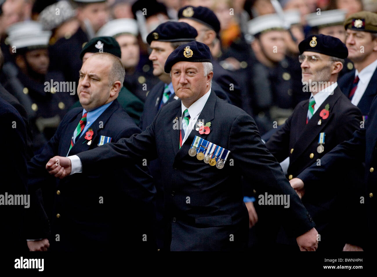 I veterani con le medaglie e di papavero marzo passato presso il cenotafio in Whitehall sul ricordo domenica per commemorare le vittime della guerra Foto Stock