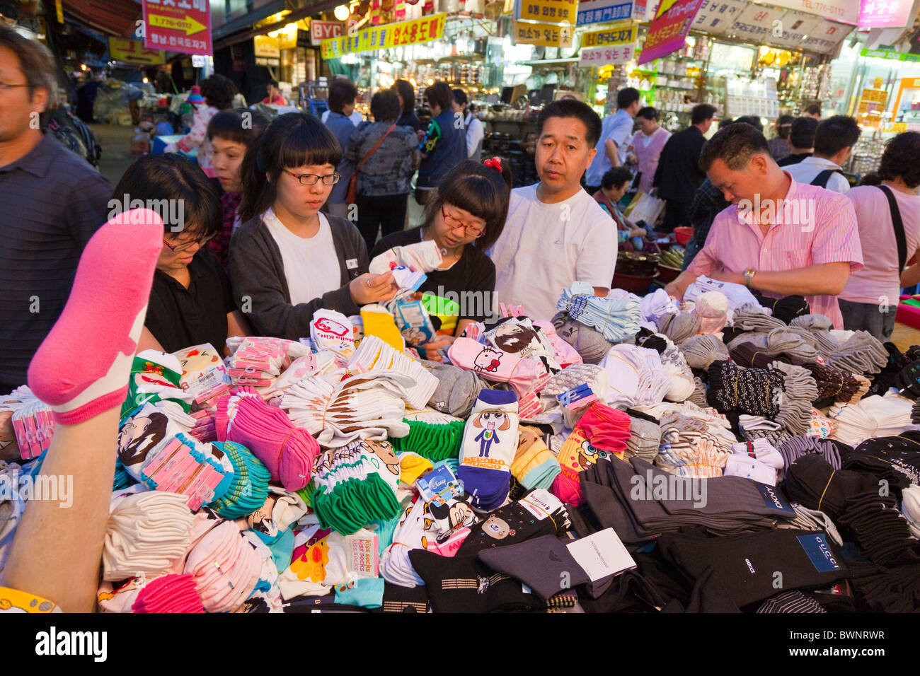 I coreani lo shopping al bancarella vendendo i calzini al mercato di Namdaemun a Seoul Corea del Sud al tramonto. JMH3853 Foto Stock