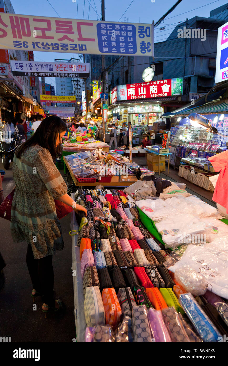 Il coreano donna shopping in stallo la vendita di portamonete in al mercato di Namdaemun a Seoul Corea del Sud al tramonto. JMH3854 Foto Stock