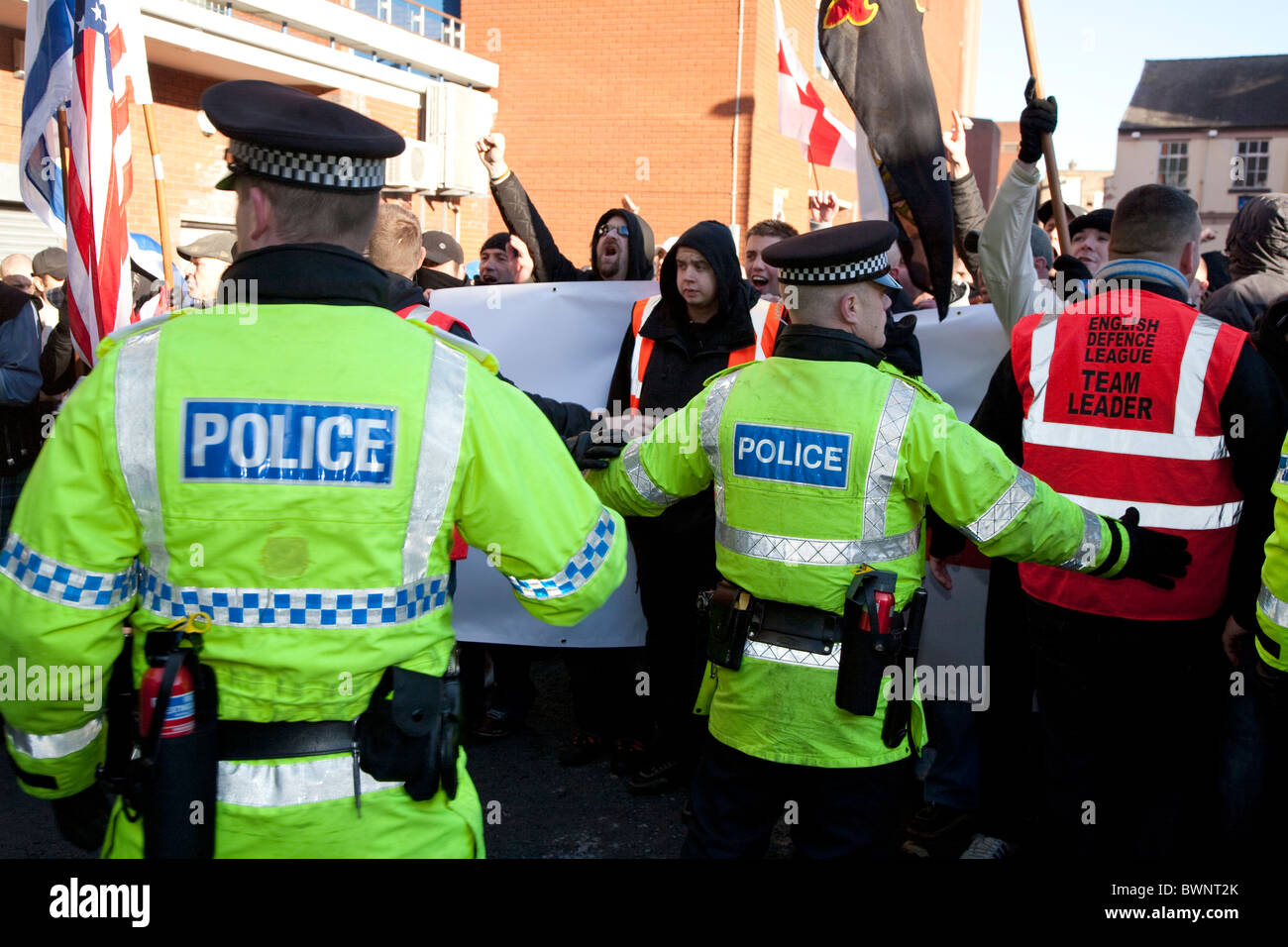 Gli ufficiali di polizia provare e controllo della difesa inglese league edl manifestanti durante un anti islamico di marcia di protesta a Preston lancashire Foto Stock