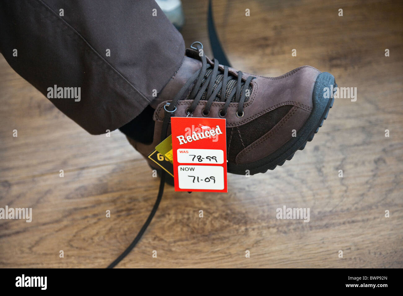 Il Regno Unito, l'Europa. Persona cercando su un nuovo paio di scarpe con un etichetta ridotta nel negozio vendita Foto Stock