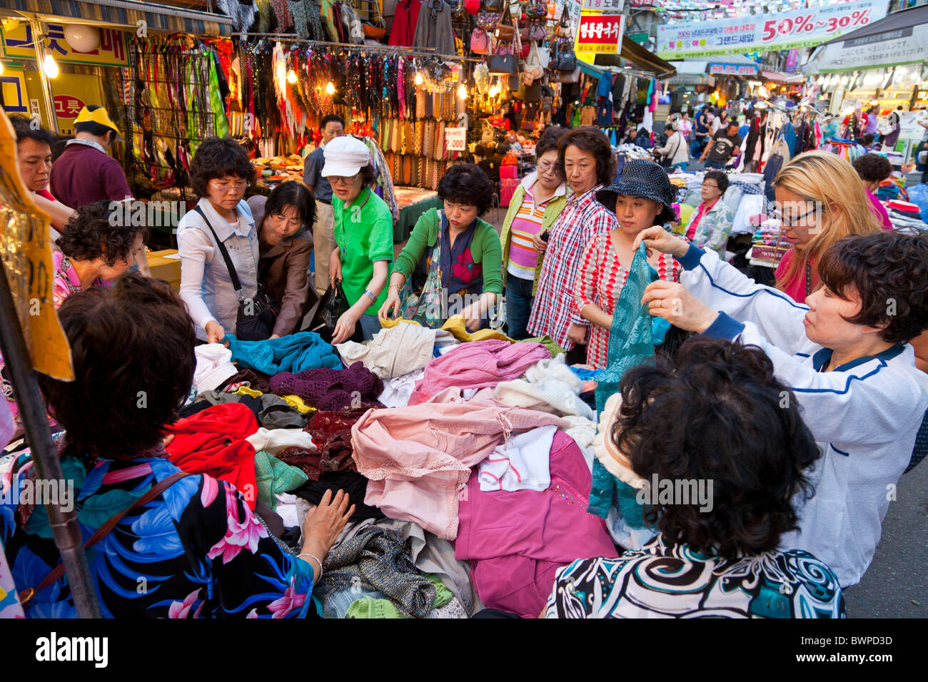 Le donne coreane shopping in stallo la vendita di abbigliamento in al mercato di Namdaemun a Seoul Corea del Sud al tramonto. JMH3852 Foto Stock