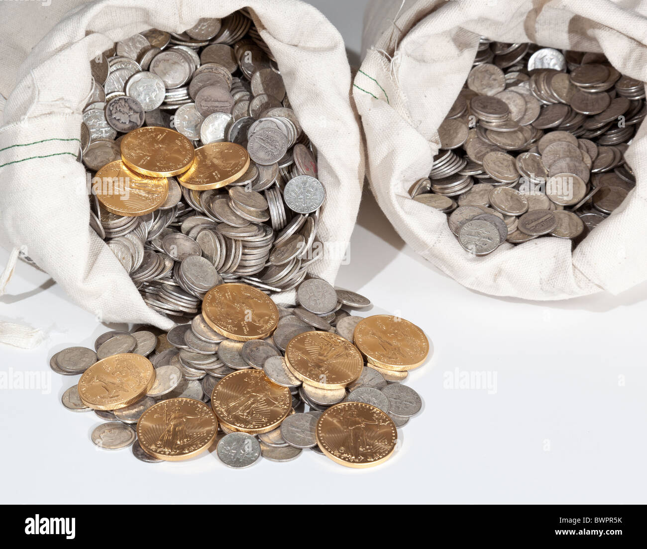 Sacco biancheria di puro vecchie monete d'argento utilizzato per investire in argento come una merce con una selezione di Golden Eagle monete d oro Foto Stock