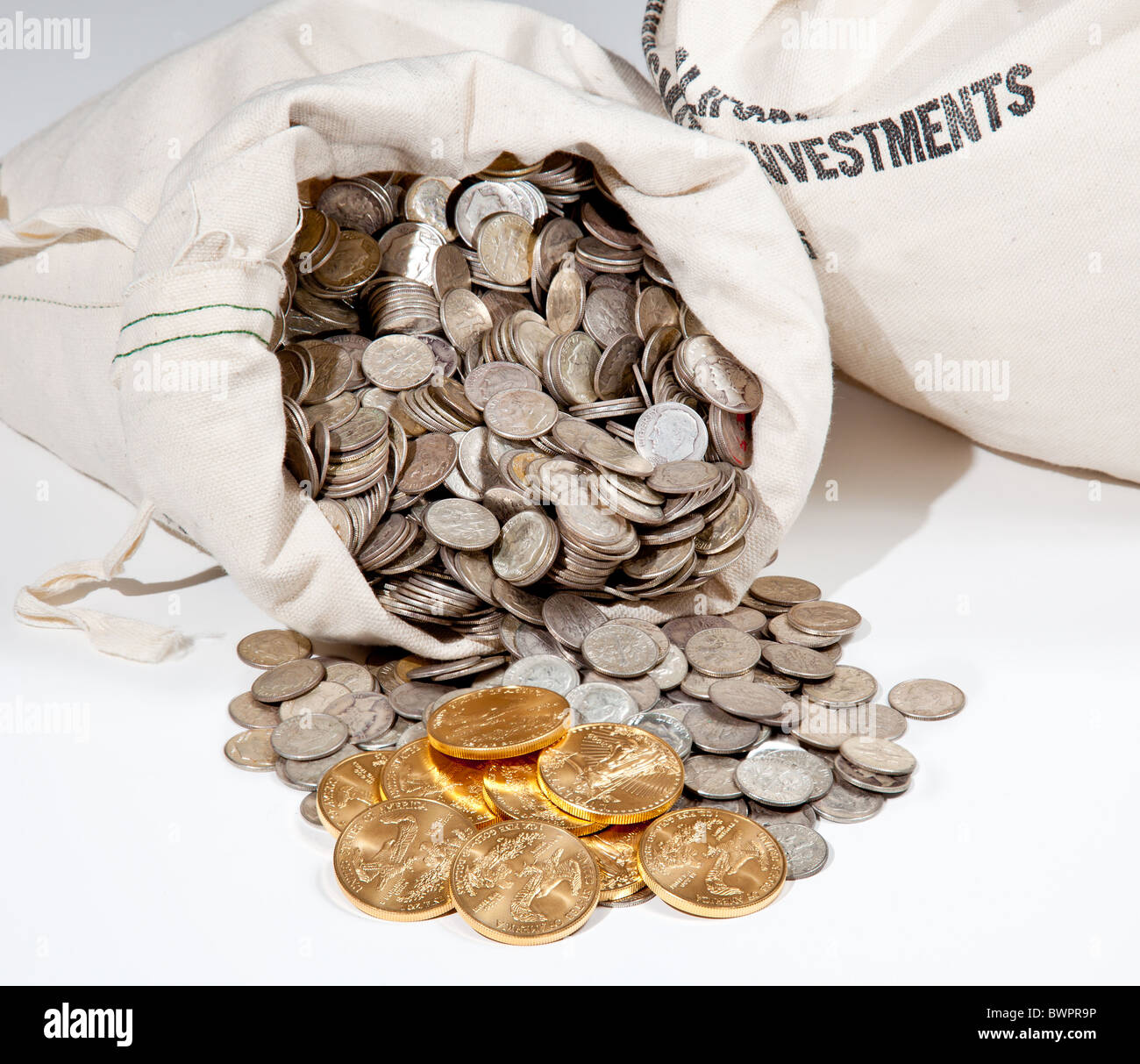 Sacco biancheria di puro vecchie monete d'argento utilizzato per investire in argento come una merce con una selezione di Golden Eagle monete d oro Foto Stock