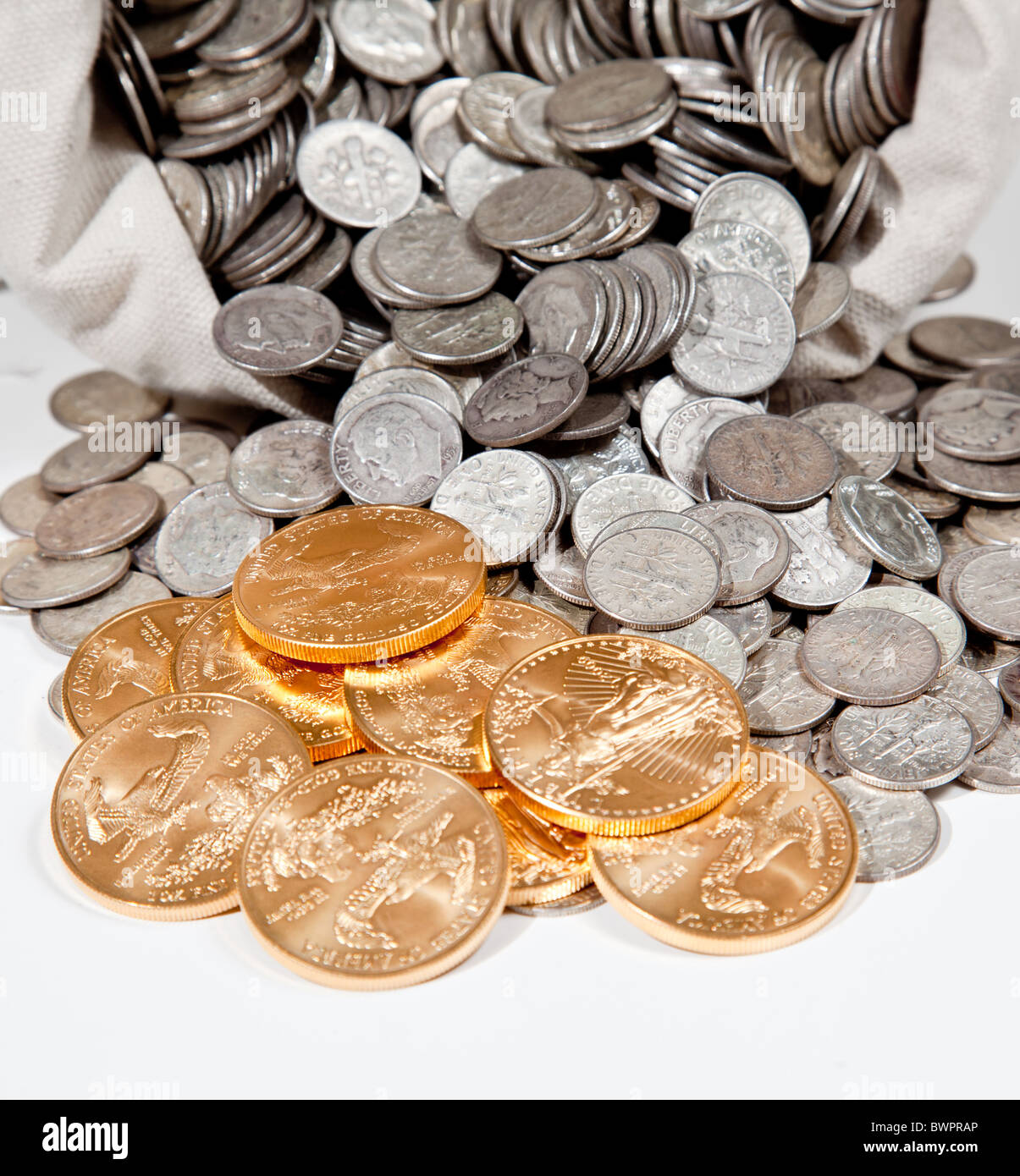 Sacco biancheria di puro vecchie monete d'argento utilizzato per investire in argento come una merce con una selezione di Golden Eagle monete d oro Foto Stock
