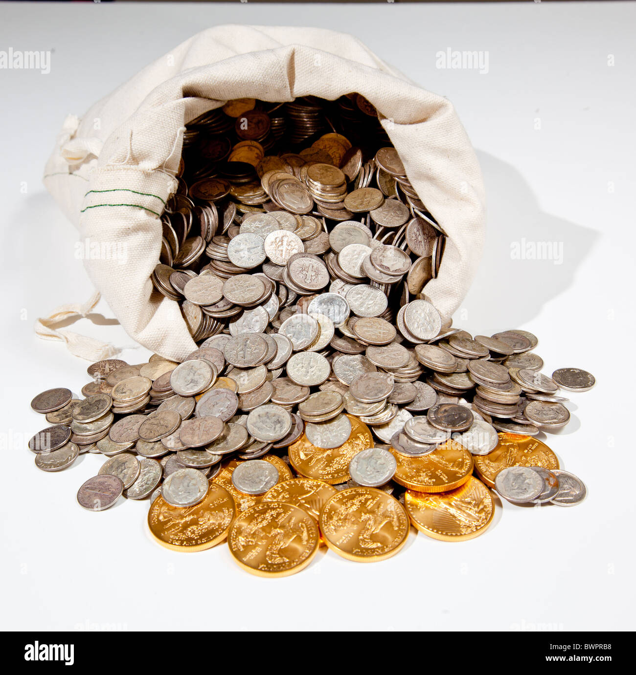 Sacco biancheria di puro vecchie monete d'argento utilizzato per investire in argento come una merce con una selezione di Golden Eagle monete d oro Foto Stock