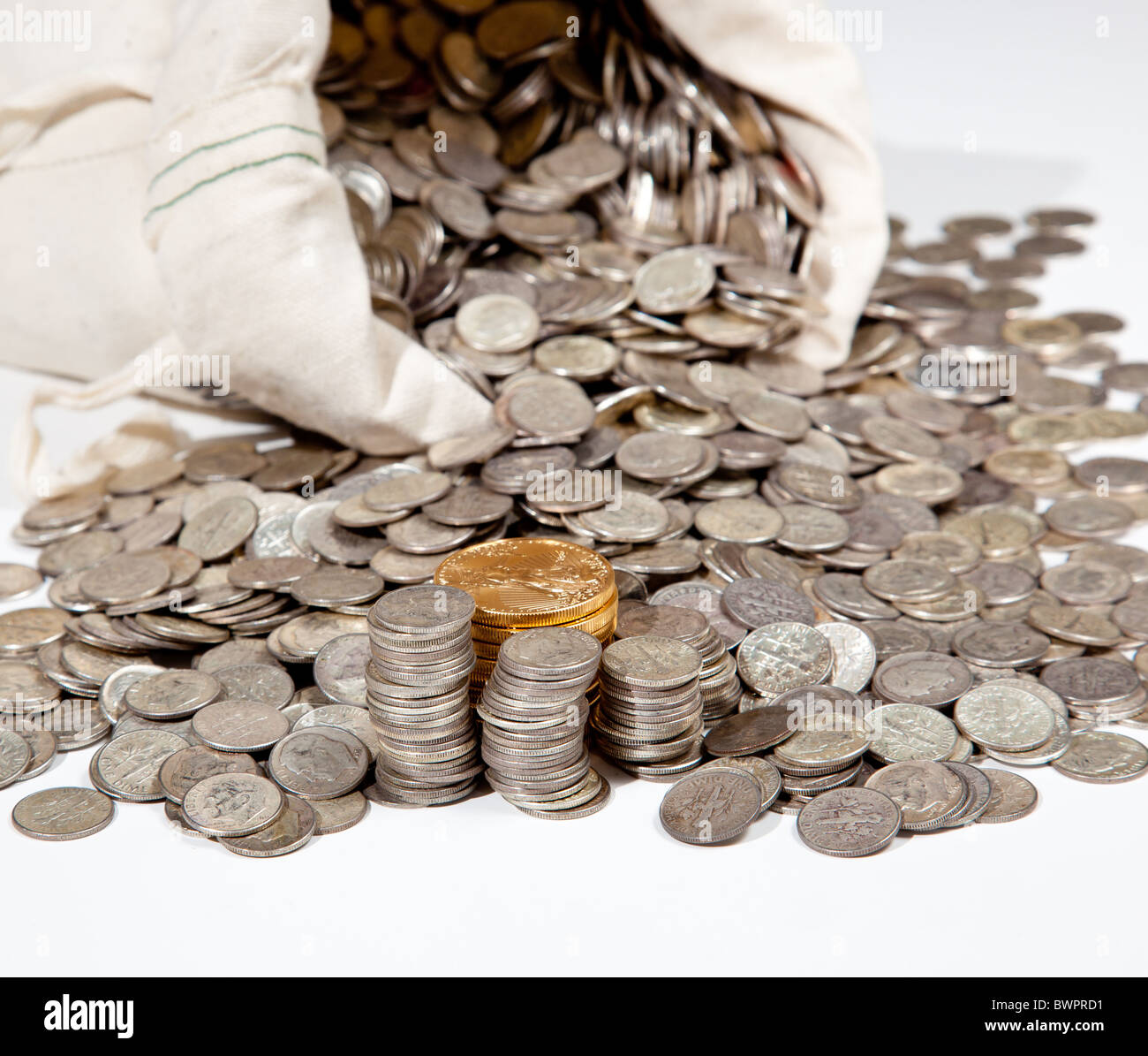 Sacco biancheria di puro vecchie monete d'argento utilizzato per investire in argento come una merce con una selezione di Golden Eagle monete d oro Foto Stock