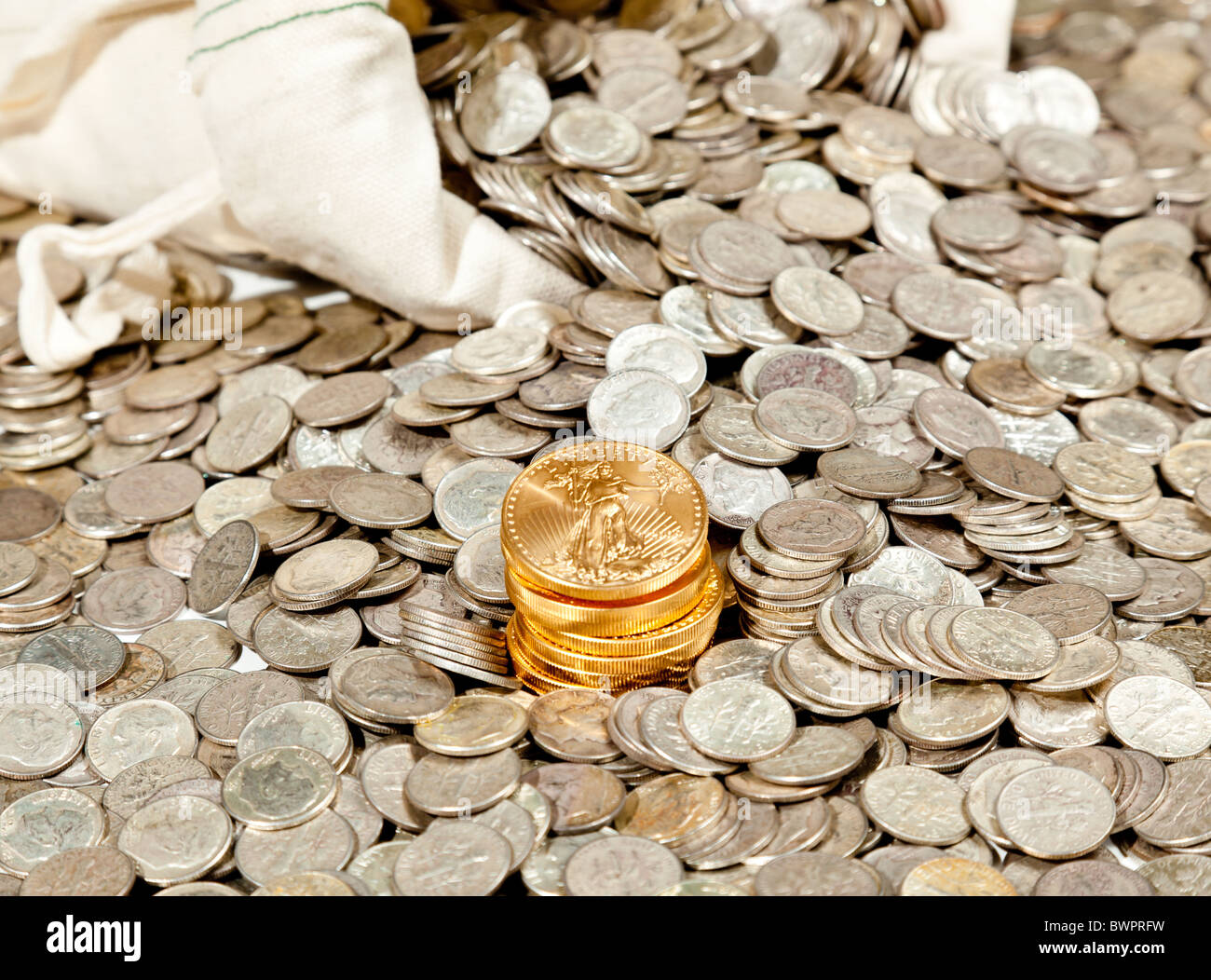Sacco biancheria di puro vecchie monete d'argento utilizzato per investire in argento come una merce con una selezione di Golden Eagle monete d oro Foto Stock