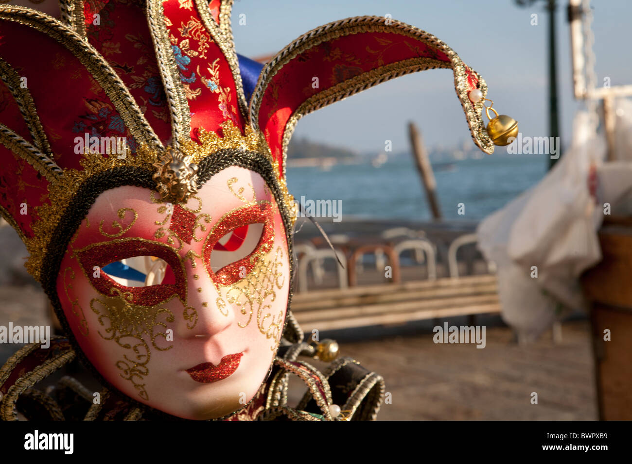 Una maschera veneziana in una fase di stallo dal lungomare che si affaccia su Piazza San Marco bacino. Foto Stock