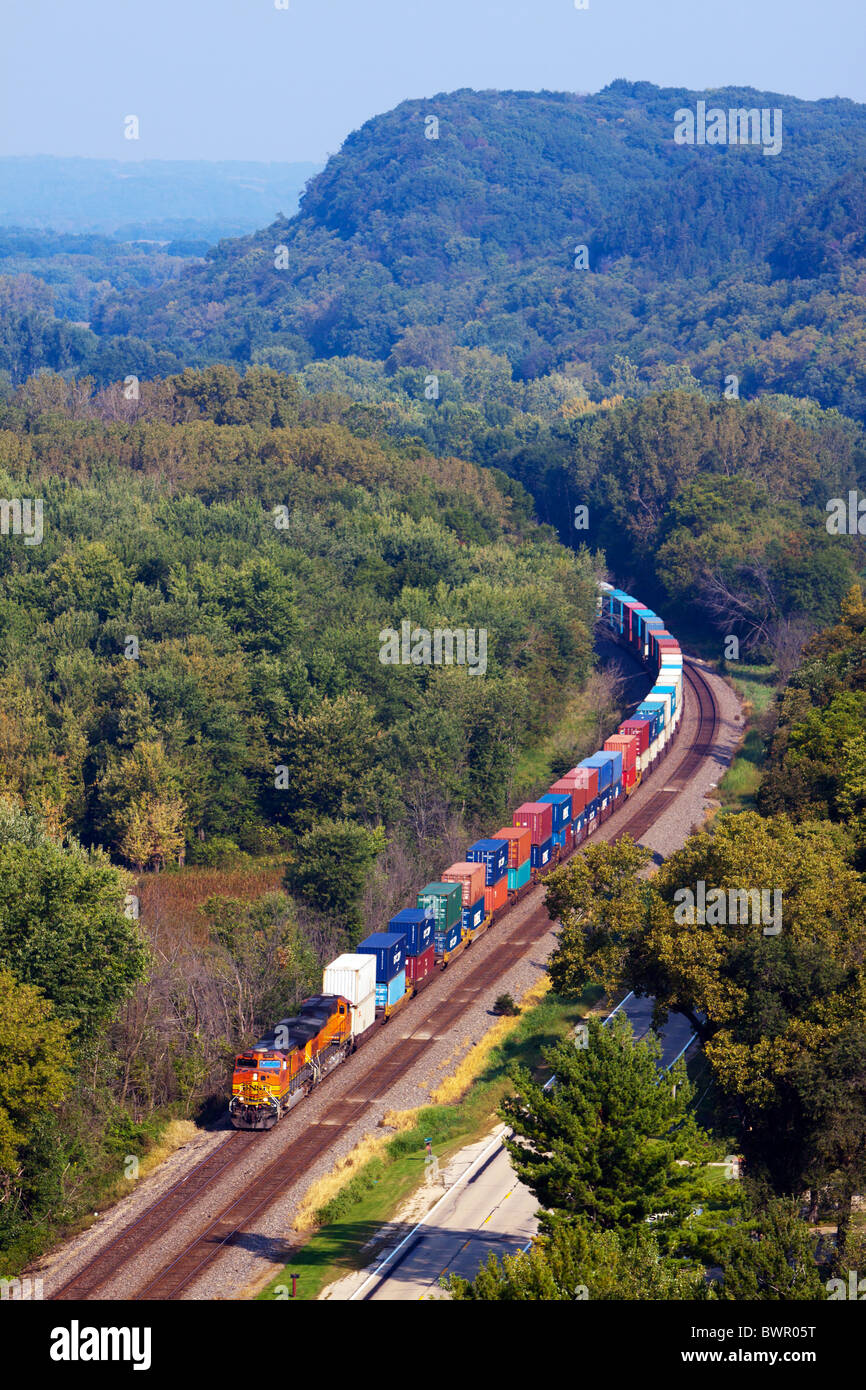 Una ferrovia BNSF treno intermodale crociere attraverso i boschi lungo il fiume Mississippi nei pressi di savana, IL. Foto Stock