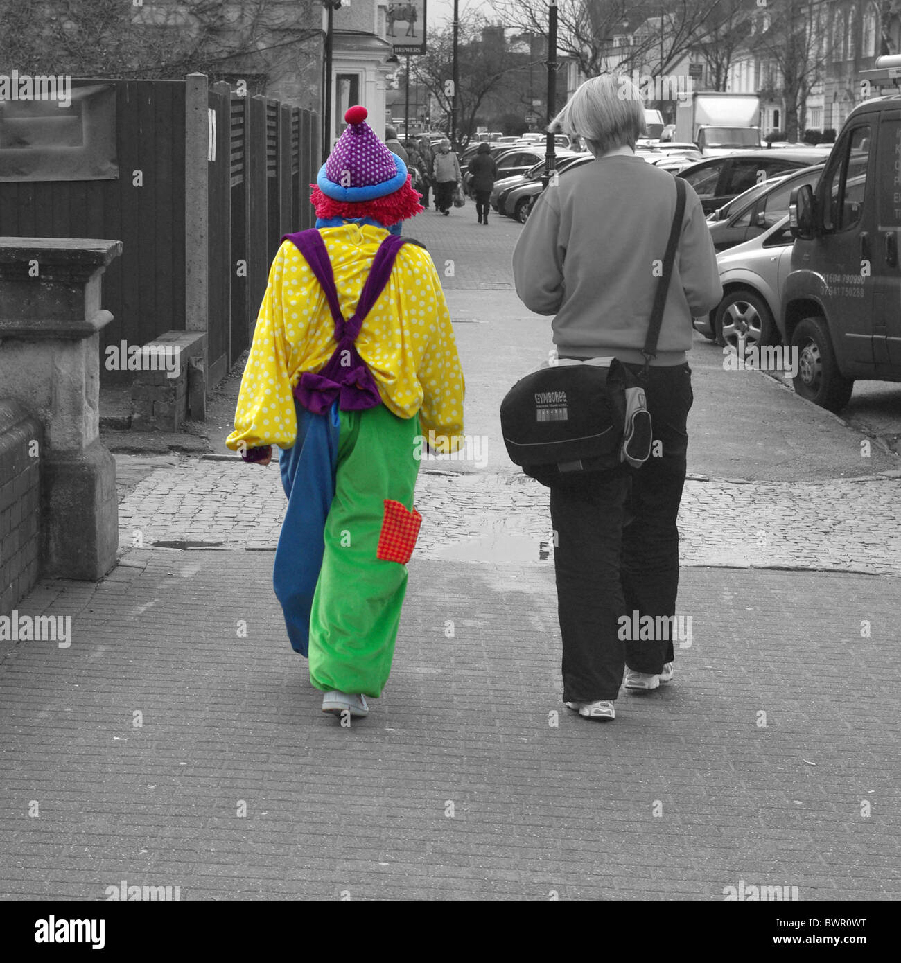 Due ragazze, uno vestito come un clown, presso il Pancake Race Olney, Bucks Foto Stock