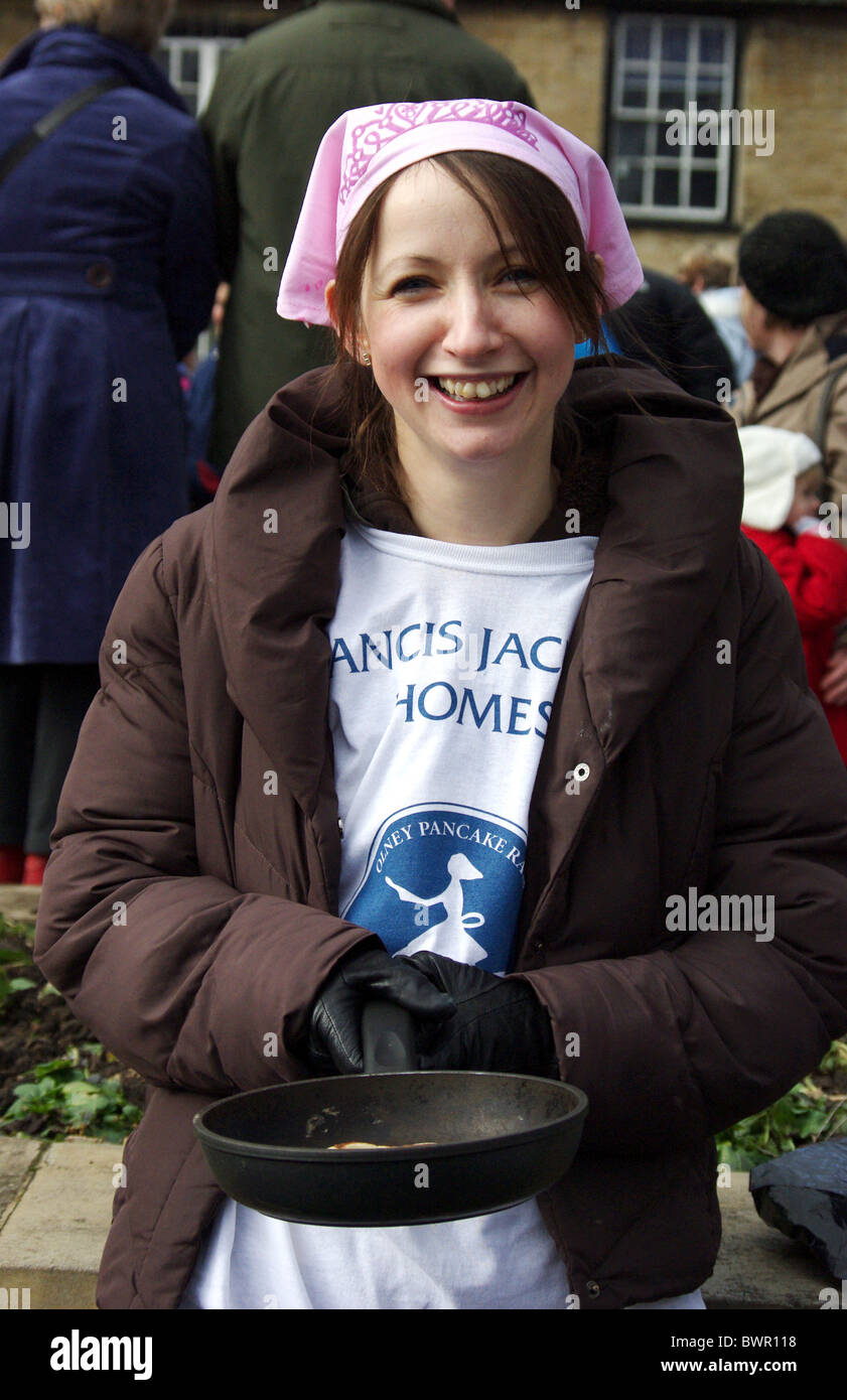 Un concorrente di sesso femminile nel ben noto Pancake gara di Olney, Buckinghamshire, UK Foto Stock