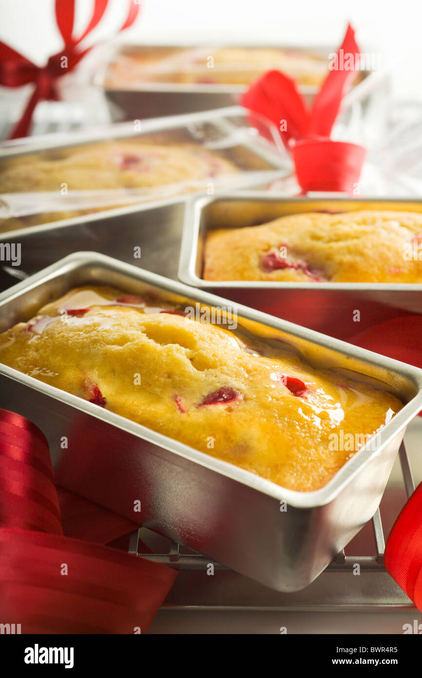 Vetrata Mini Lemon-Cranberry tè Pane. Presentati nel loro stampo di cottura su una griglia di raffreddamento. Foto Stock