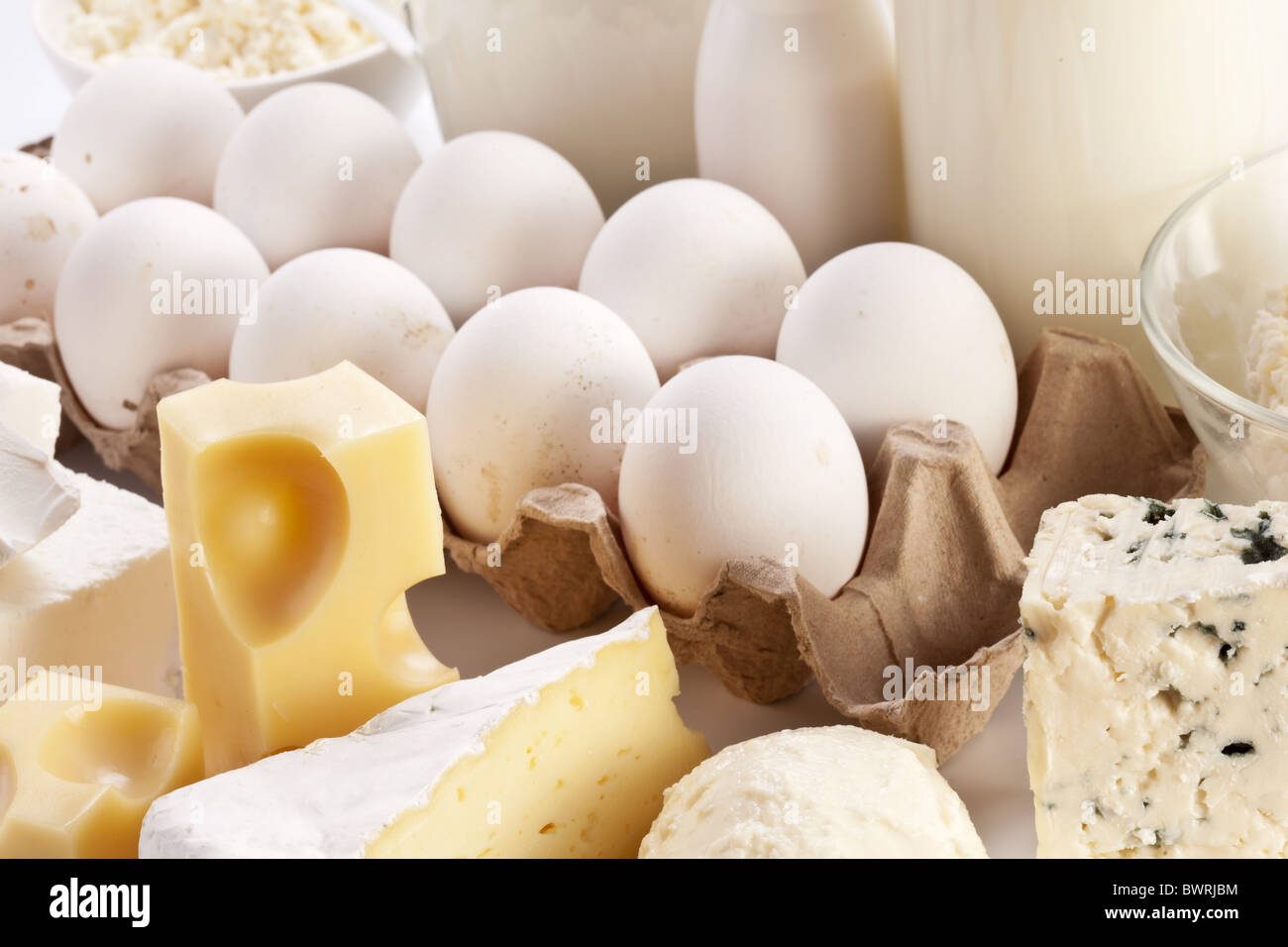 Prodotti proteici: formaggio, panna, latte, uova. Su uno sfondo bianco. Foto Stock