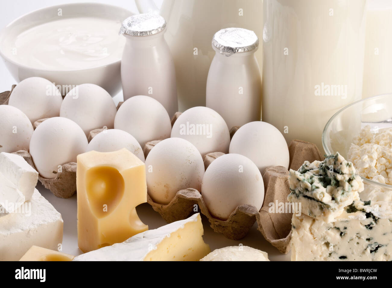 Prodotti proteici: formaggio, panna, latte, uova. Su uno sfondo bianco. Foto Stock