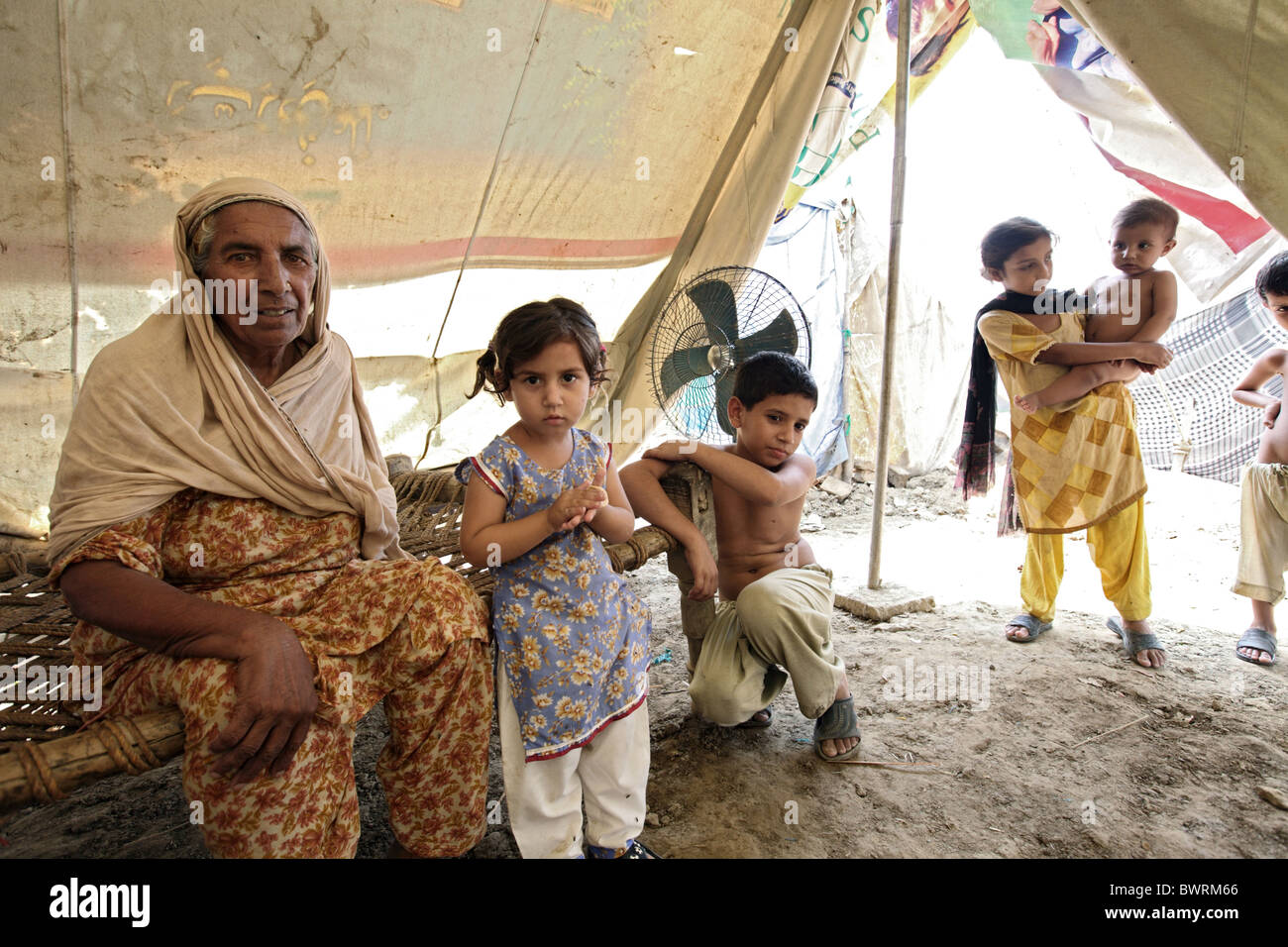 Madre con i suoi figli in un campo di rifugiati dopo la catastrofe provocata dalle inondazioni, Charsadda, Pakistan Foto Stock