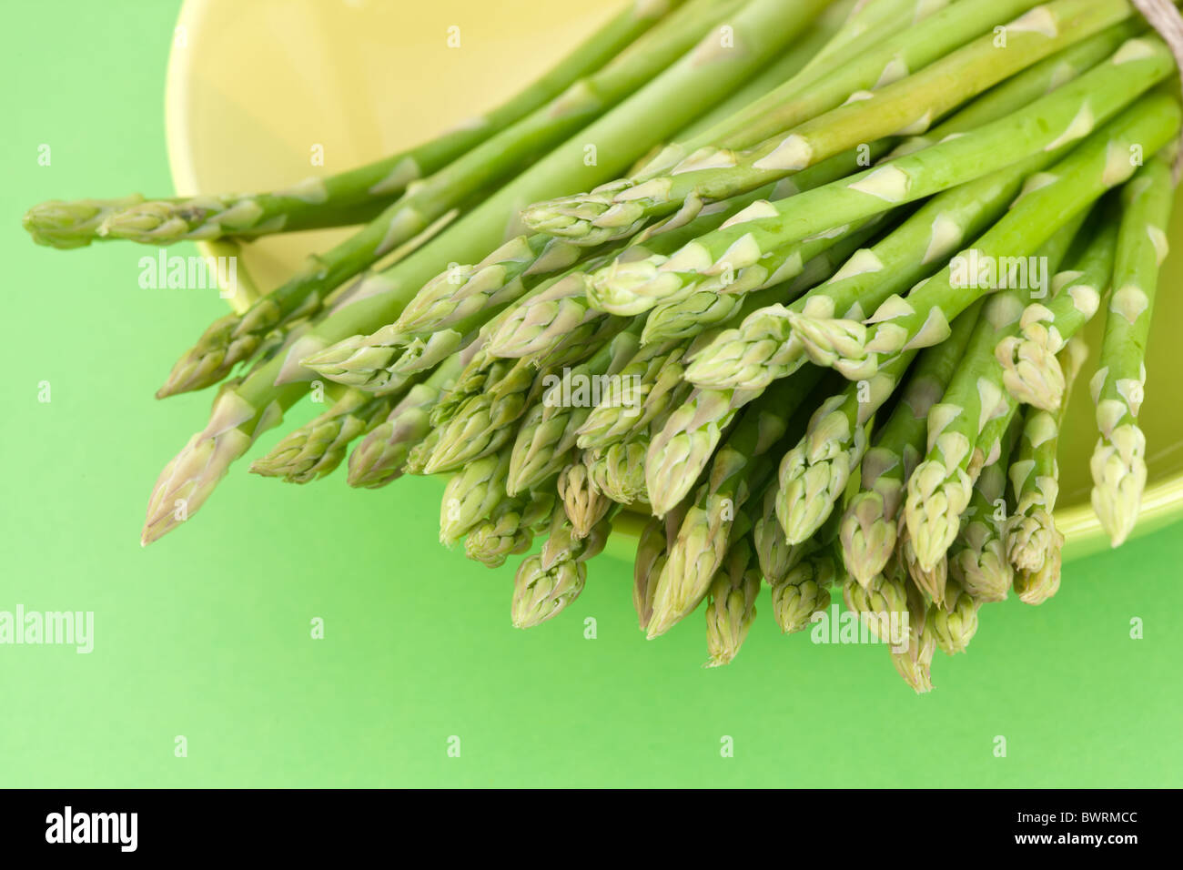 Un covone di asparagi su uno sfondo verde. Foto Stock