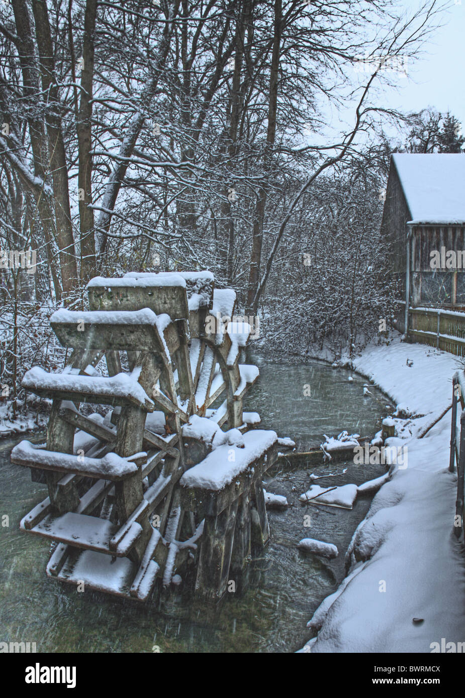 Neve invernale su una ruota del mulino sul fiume, sfondo romantico rurale stagionale Foto Stock