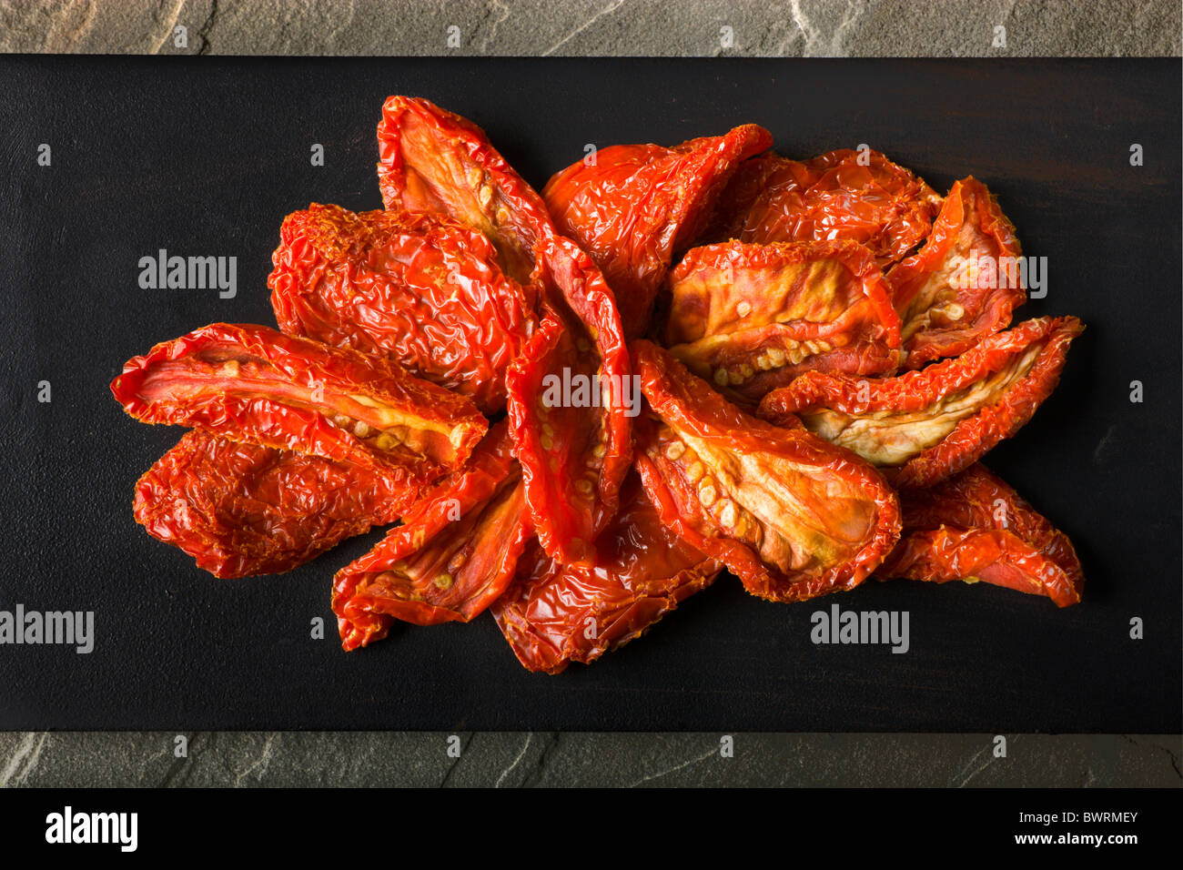 Un paio di pomodori Sun-Dried su uno sfondo nero. Foto Stock