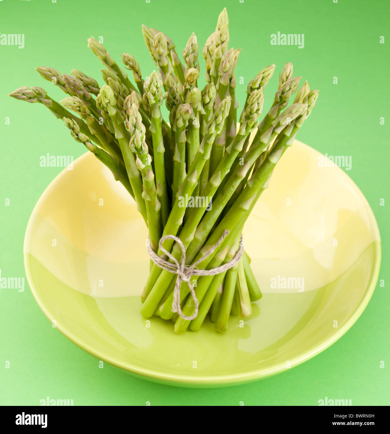 Un covone di asparagi su uno sfondo verde. Foto Stock