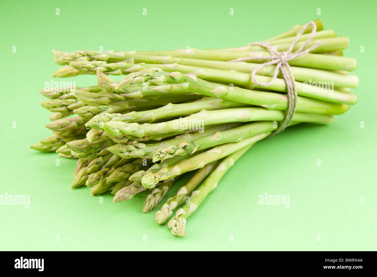 Un covone di asparagi su uno sfondo verde. Foto Stock