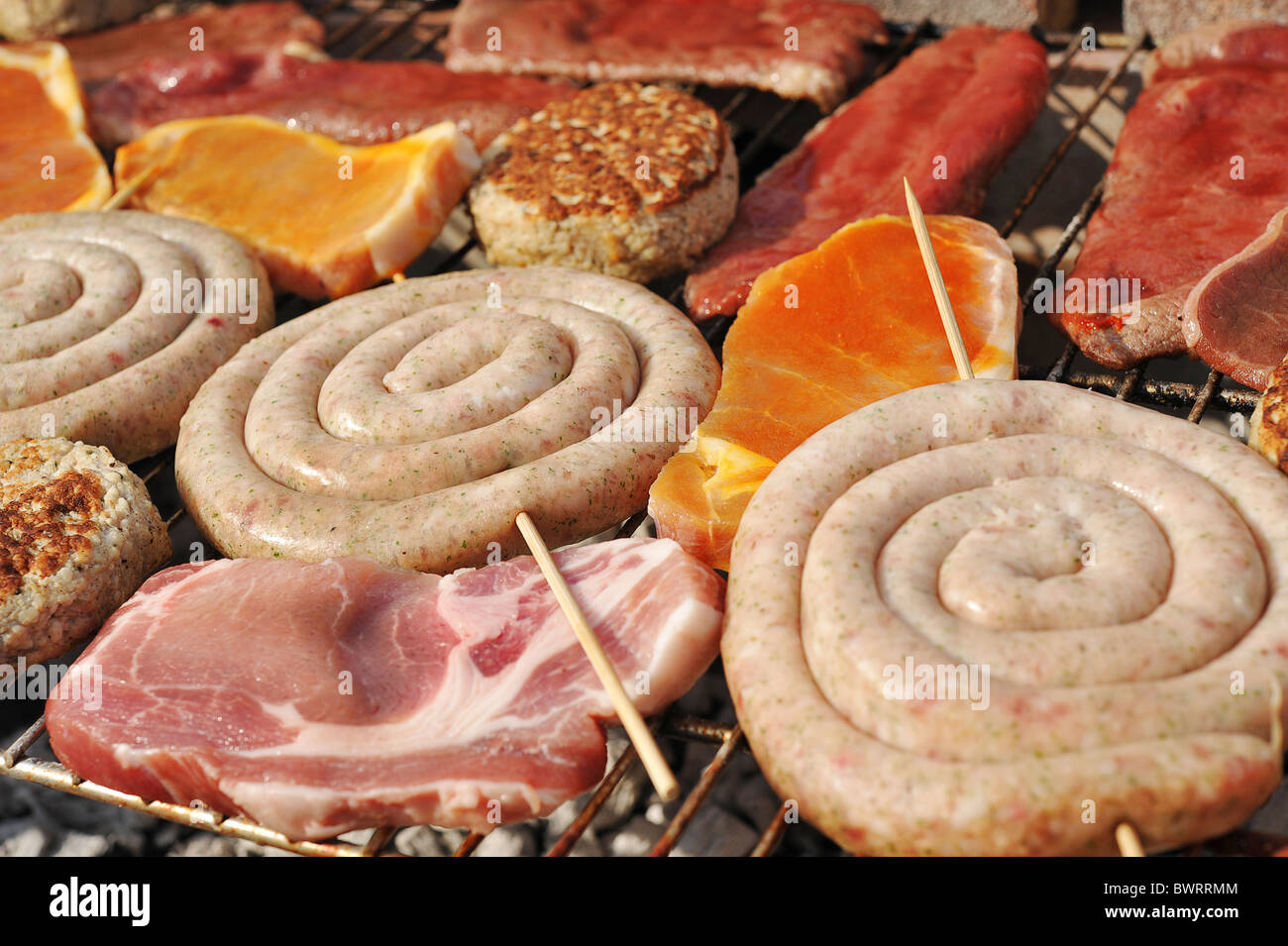 Carne cruda collocato su un barbecue a carbone grill Foto Stock