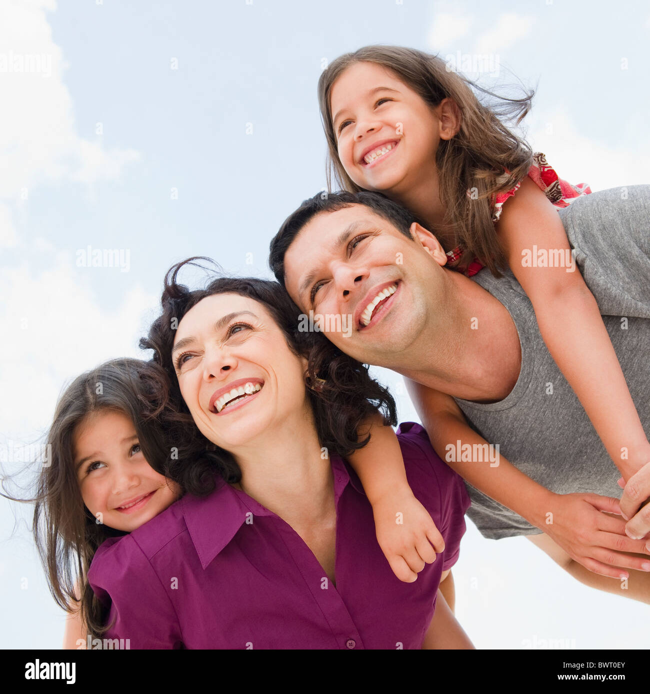 Sorridente dando i genitori di mia figlia piggyback ride Foto Stock