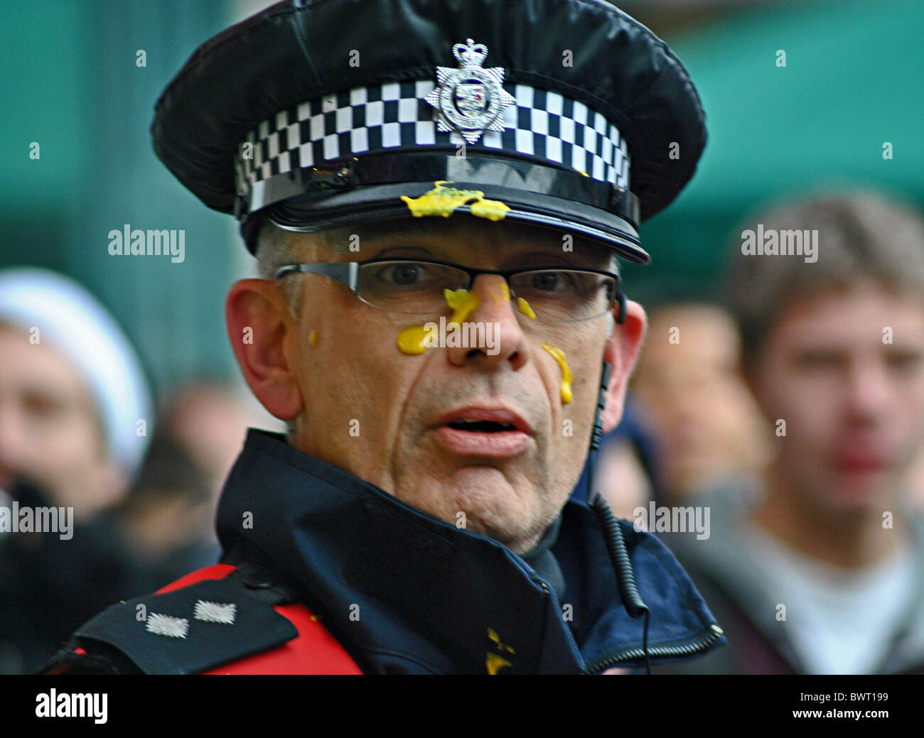 Gli agenti di polizia sono coperte di senape, gettato a loro dagli studenti che protestavano contro un rialzo le tasse presso l'Università di Bristol Foto Stock