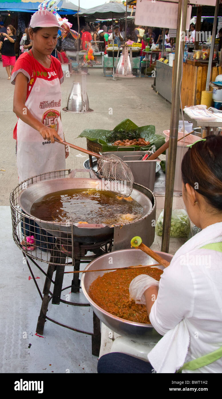 Fornitore di donna agitare per frittura a Phuket mercato del weekend, Thailandia Foto Stock