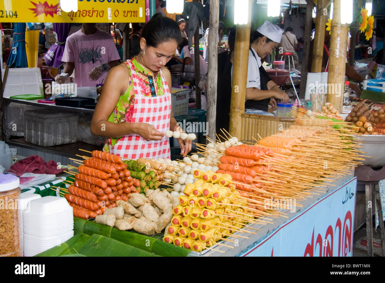 Donna di vendita del fornitore spiedini di cibo su Phuket mercato del weekend, Thailandia Foto Stock