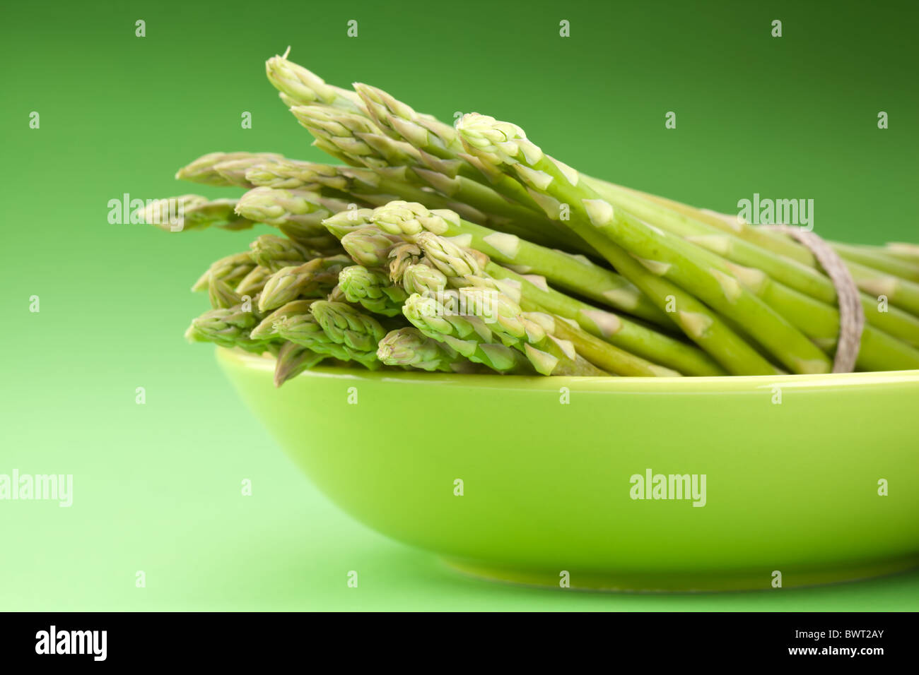 Un covone di asparagi su uno sfondo verde. Foto Stock