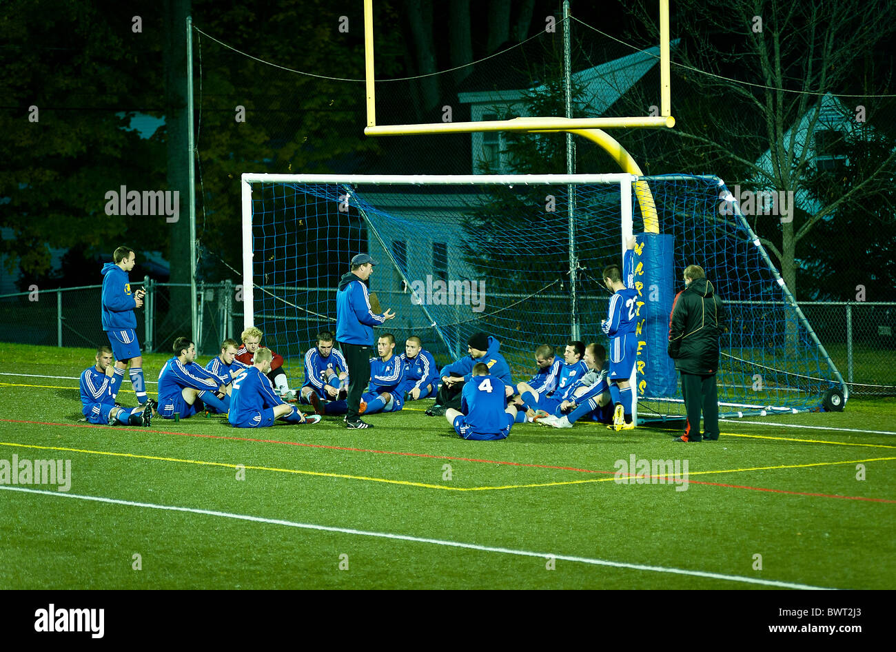 Alta scuola calcio allenatore dà tempo di emisaturazione pep talk al team. Foto Stock
