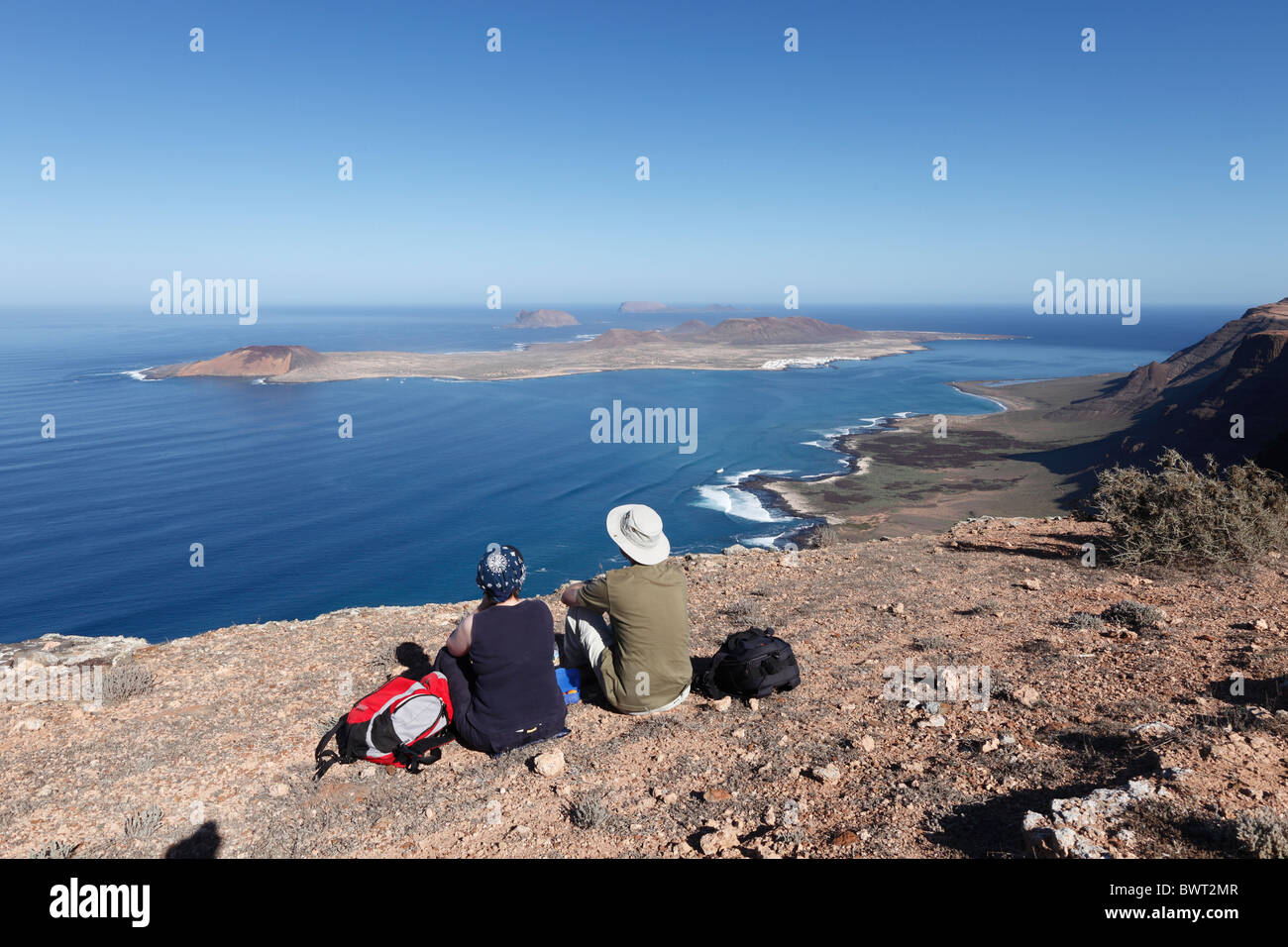 Gli escursionisti in appoggio a Risco de Famara vicino Guinate, di fronte alle isole di La Graciosa, Montaña Clara e Alegranza, Lanzarote, Foto Stock