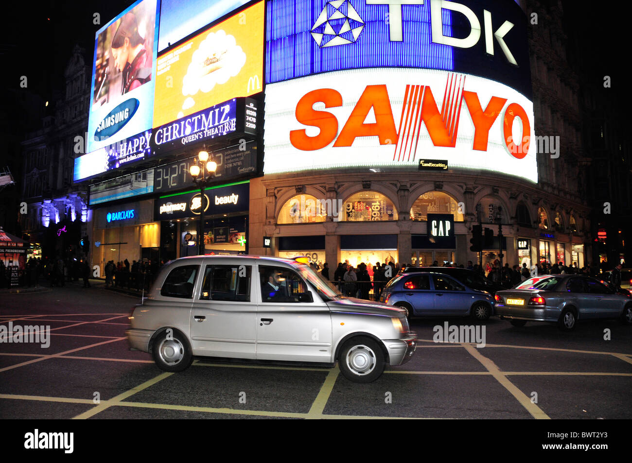 Taxi di fronte delle insegne al neon sulla Piccadilly Circus di notte, Londra, Inghilterra, Regno Unito, Europa Foto Stock