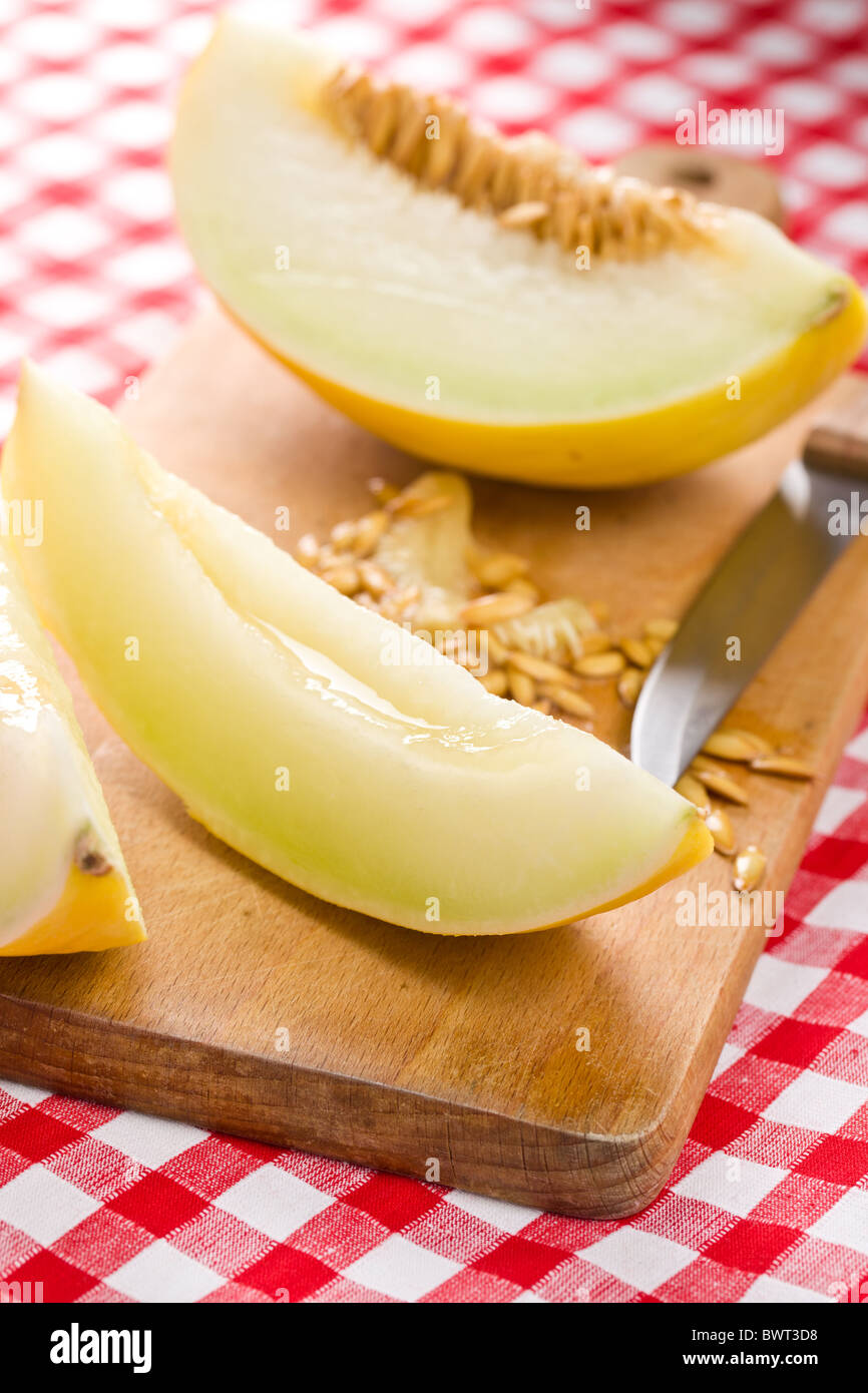 Tagliare il melone Honeydew sulla tovaglia a scacchi Foto Stock