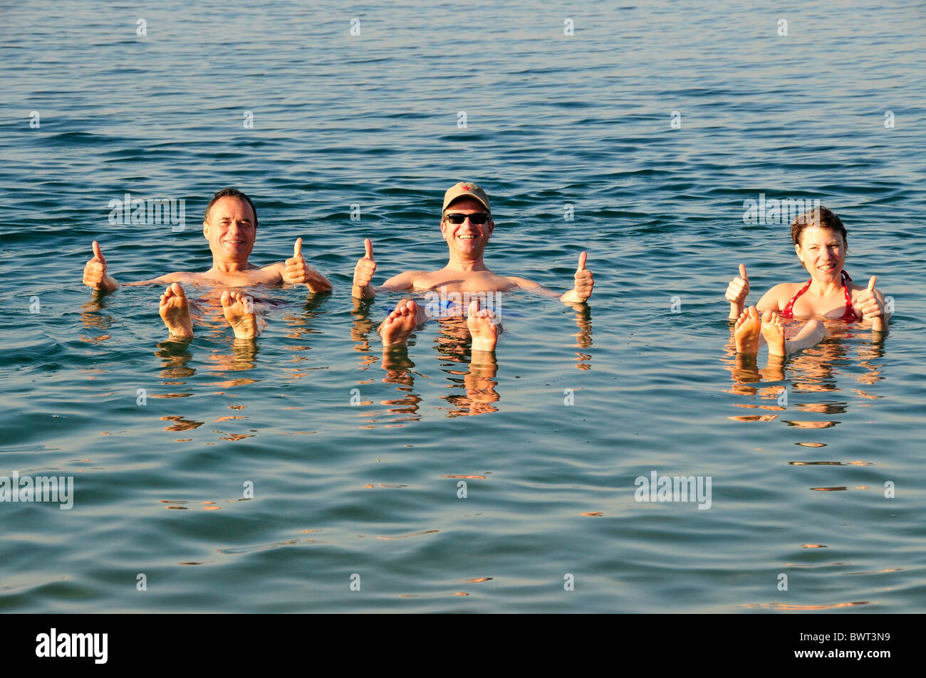 I turisti, pollice in su nel Mar Morto vicino Suwaymah, Giordania, Medio Oriente, Orient Foto Stock