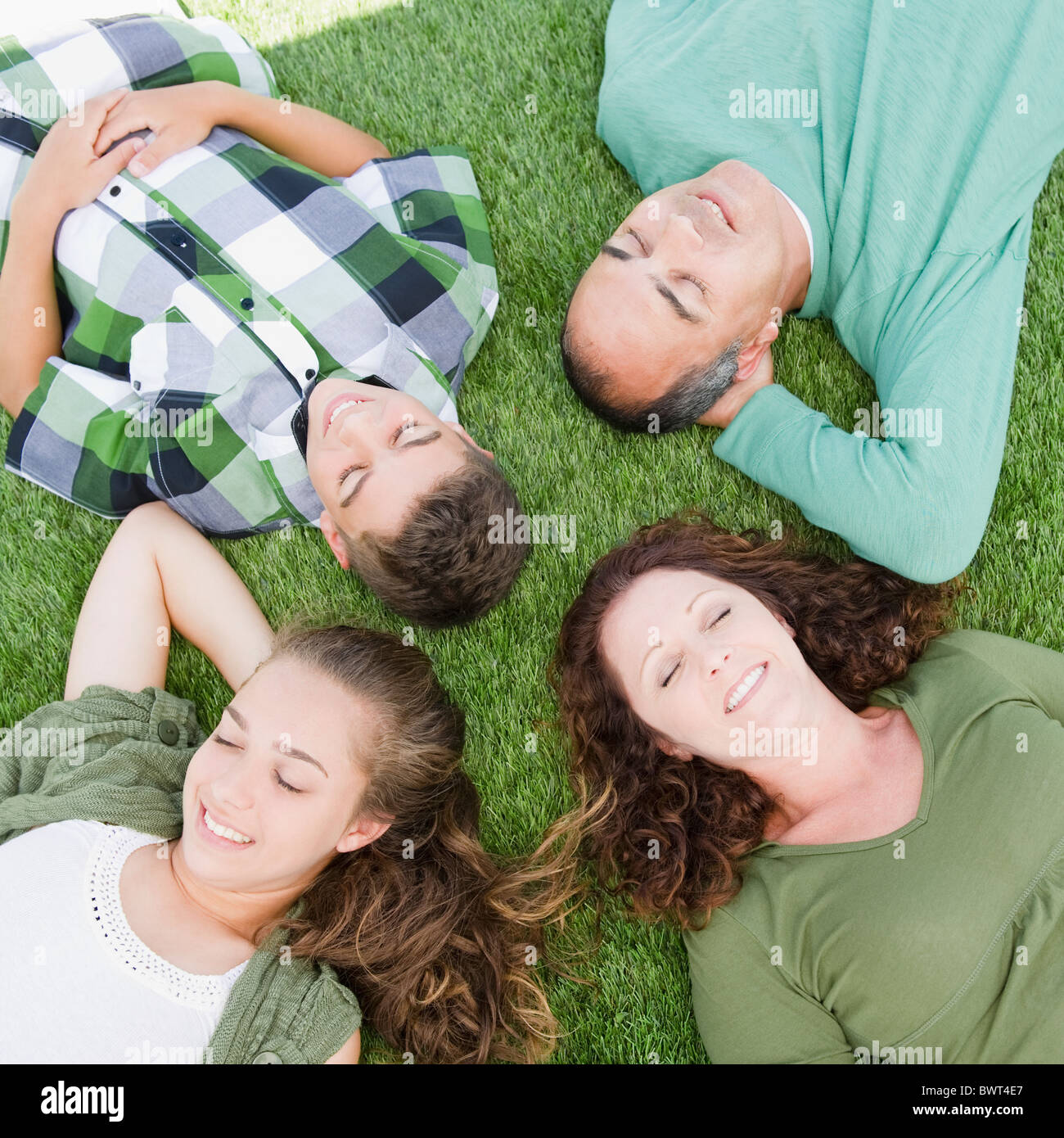 Famiglia di origine ispanica che stabilisce in erba insieme Foto Stock